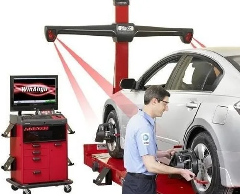 Technician checking wheel alignment readings